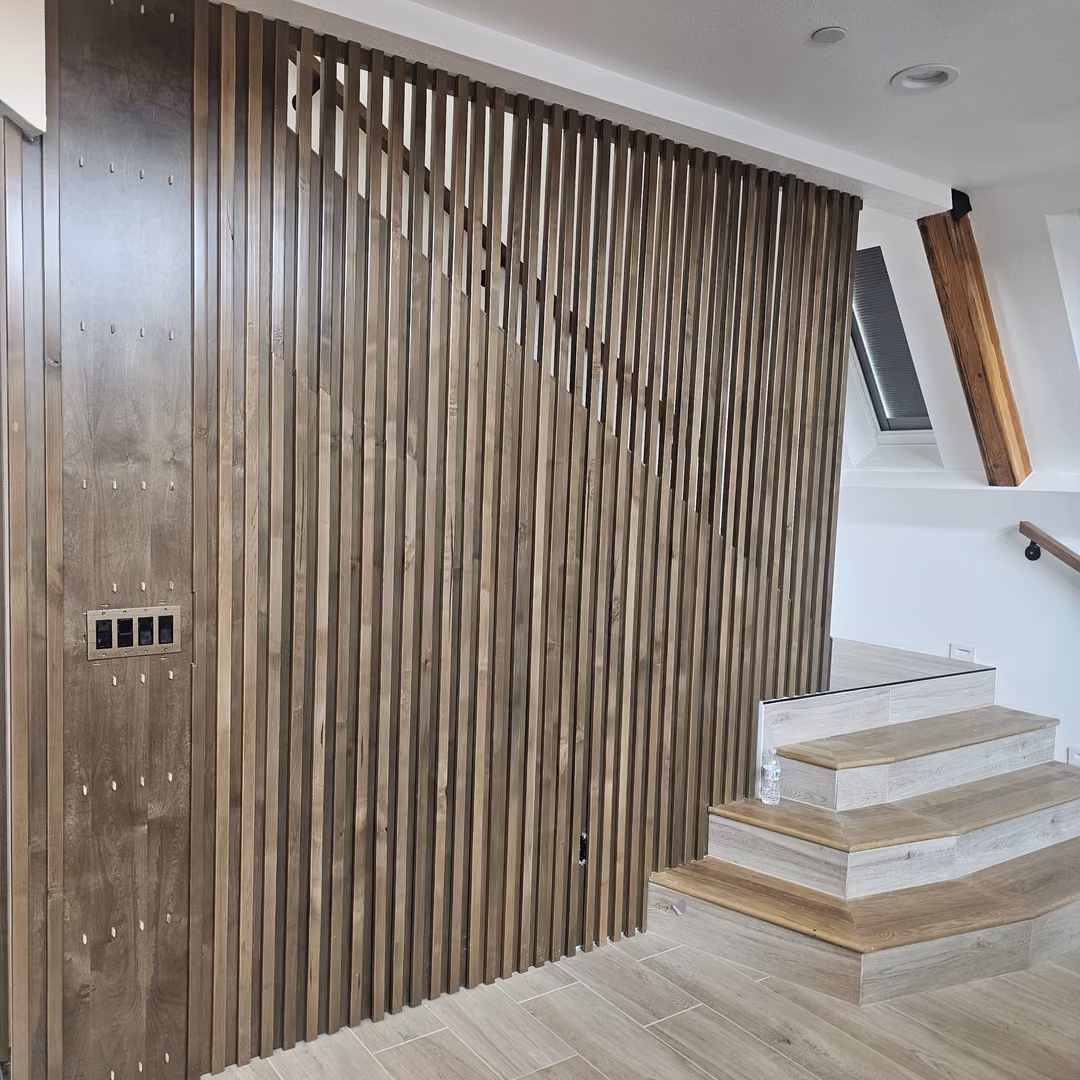 Wood slat wall and riveted panel beside a staircase